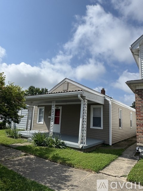 A small house with a red door and white porch.