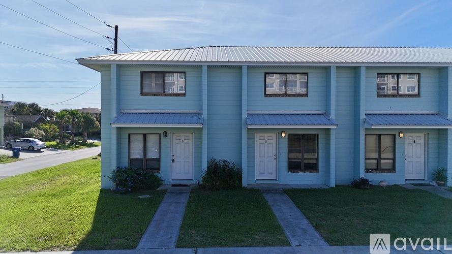 A blue house with a white door and windows is for sale.
