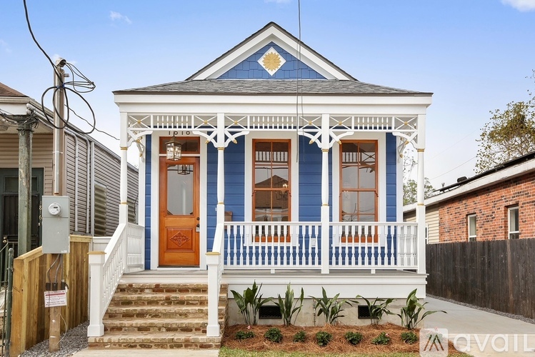 A blue and white house with a brown door and windows.