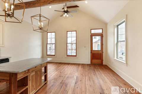 A large open room with wooden floors and a kitchen island.
