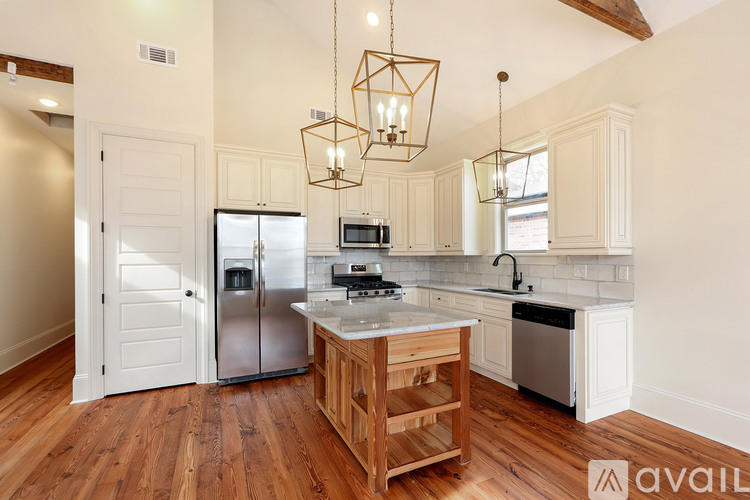 A kitchen with wooden floors and a white refrigerator.