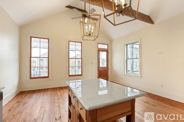 A kitchen with a marble countertop and wooden floors.