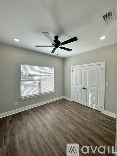 A room with a ceiling fan and a window with blinds.