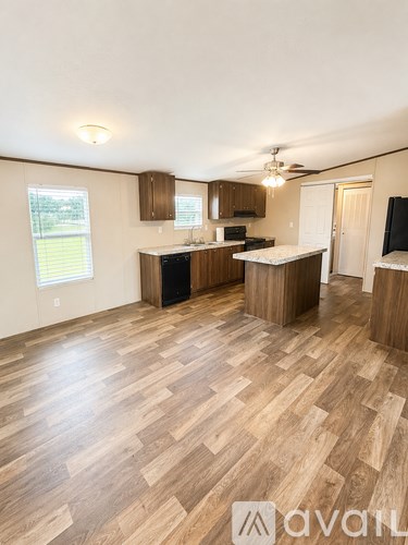 A kitchen with wooden floors and cabinets.