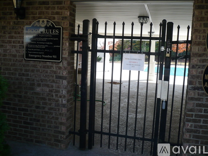 A black gate with a sign that says "POOL RULES" on it.