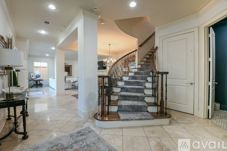 A spacious foyer with a staircase and a rug.