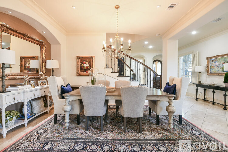 A dining room with a large table and chairs.
