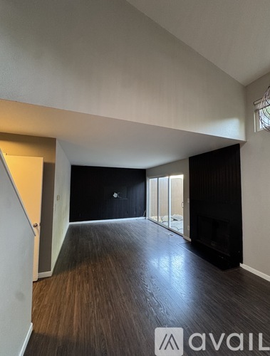 A room with wooden flooring and a large window.