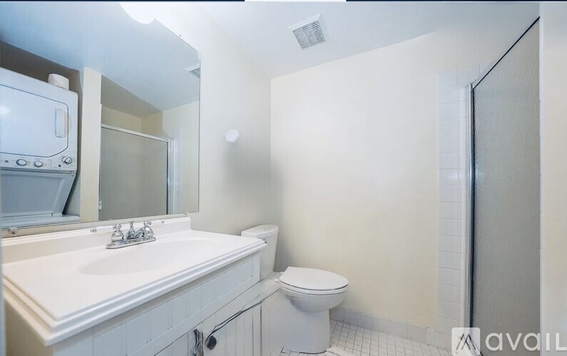 A bathroom with a toilet, sink, and mirror.