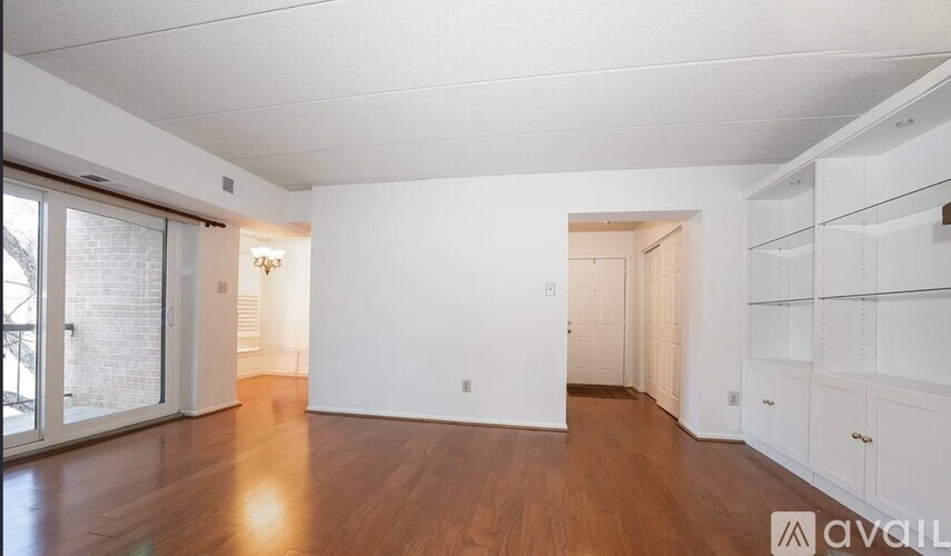 A spacious room with wooden floors and white walls.
