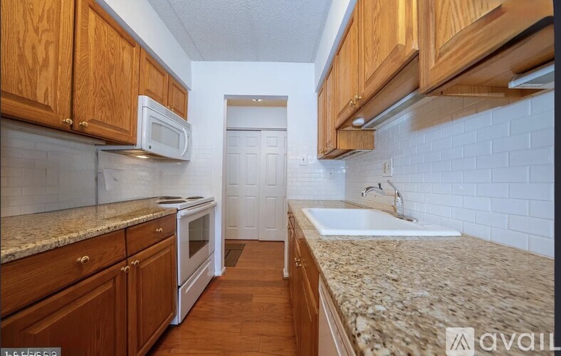 A kitchen with wooden cabinets and a granite countertop.