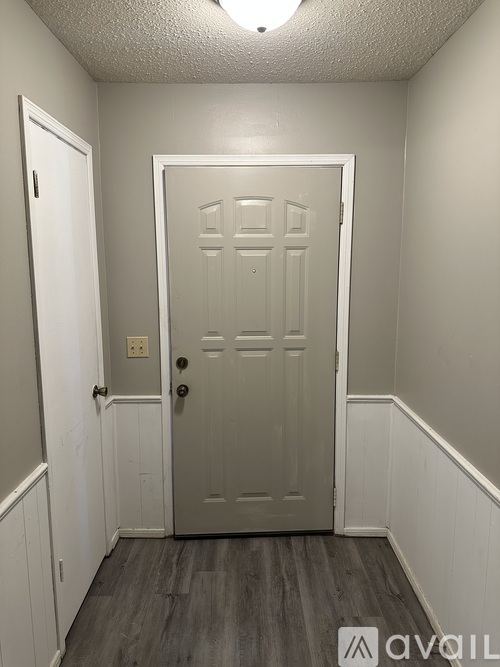 A white door with a black handle is in the middle of a room.