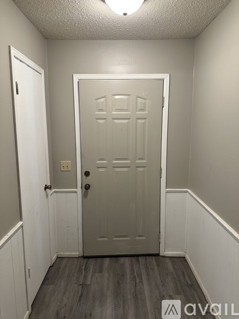 A white door with a black handle is in the middle of a room.