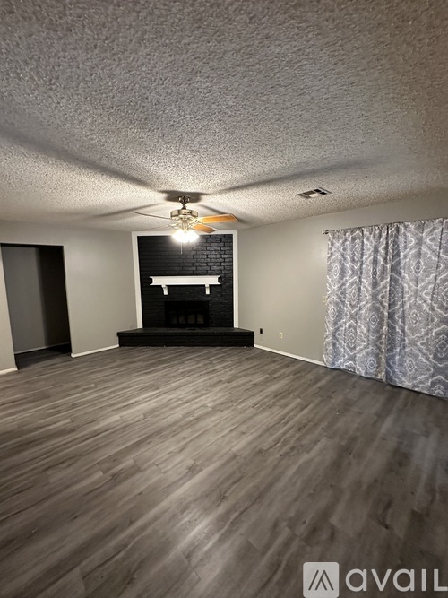 A room with wooden flooring and a fireplace.