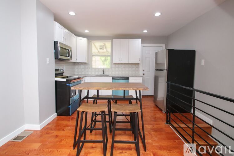 A kitchen with wooden floors and a table with four chairs.