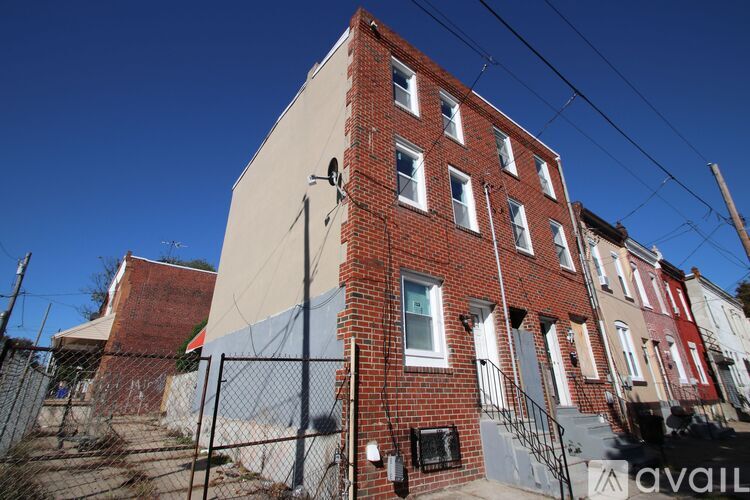 A red brick building with a sign that says "available" in front of it.