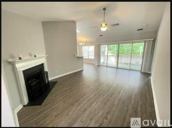 A spacious living room with a fireplace and sliding glass doors.