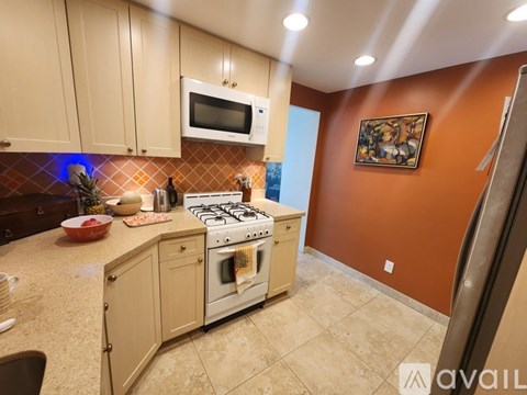 A kitchen with a stove top oven and a microwave above it.