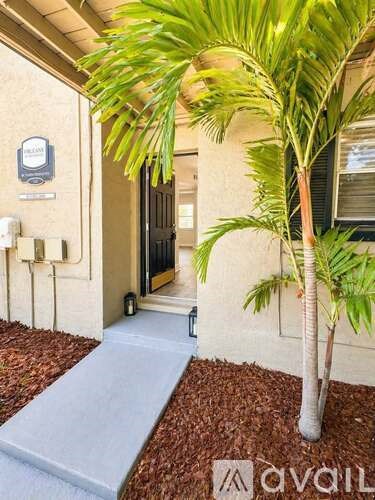 A palm tree is in front of a house with a sign that says "avail".