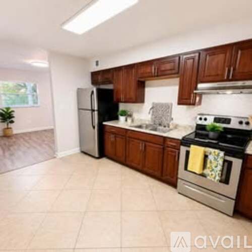 A kitchen with a stove, refrigerator, and cabinets.