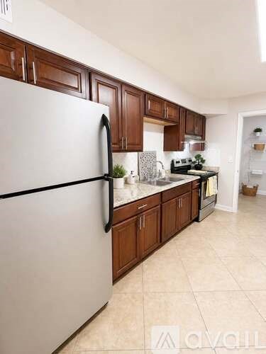 A kitchen with a white fridge and brown cabinets.