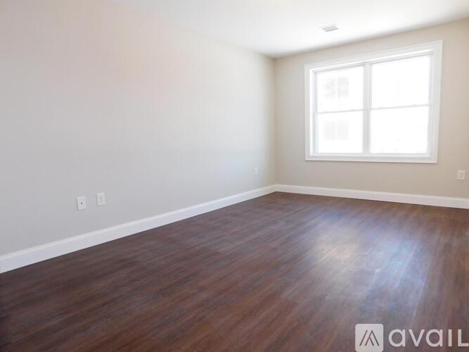 A room with wooden flooring and a window.
