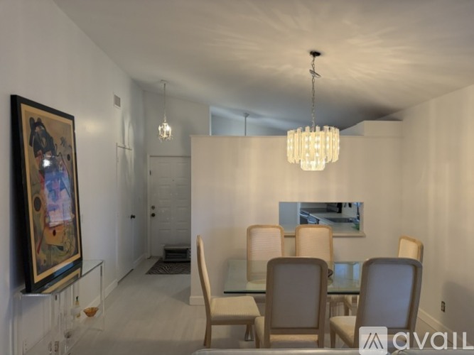 A dining room with a glass table and chairs.
