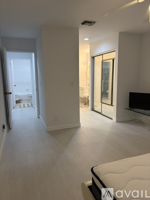 A bedroom with a large bed and a flat screen TV.