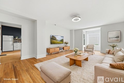 A living room with a couch, coffee table, and a painting on the wall.
