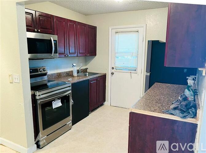 A kitchen with dark wood cabinets and stainless steel appliances.