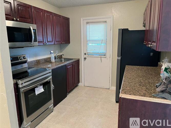 A kitchen with dark wood cabinets and stainless steel appliances.