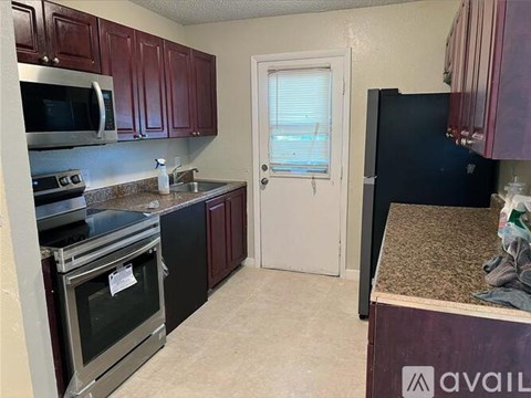 A kitchen with dark wood cabinets and stainless steel appliances.