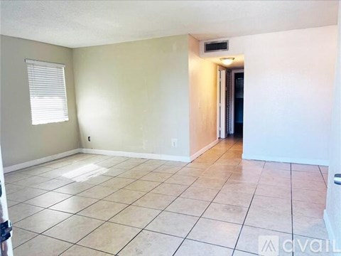 A room with tile flooring and a doorway leading to another room.