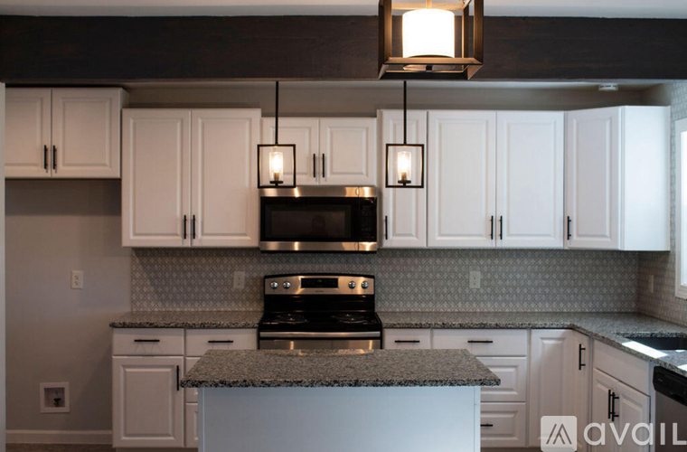 A kitchen with a granite countertop and white cabinets.