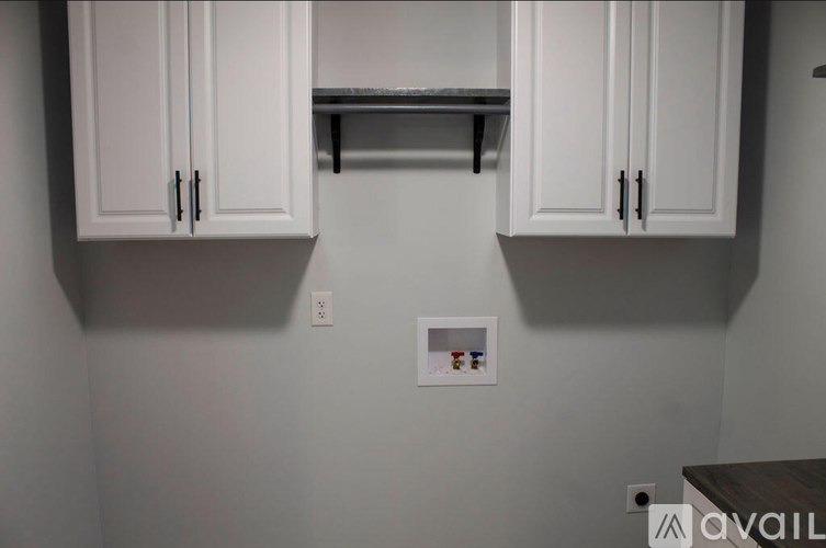 A kitchen with white cabinets and a small shelf with spices.