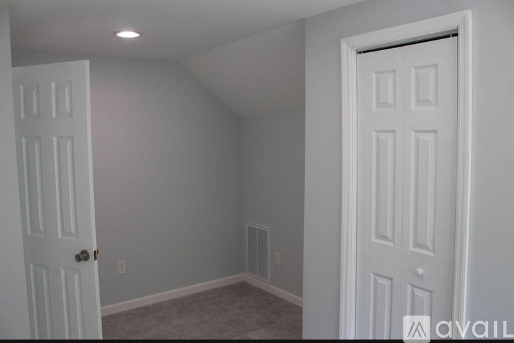 A room with two white doors and a carpeted floor.