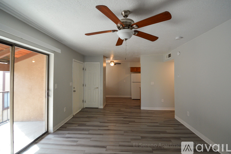 A spacious room with a ceiling fan and sliding glass doors.