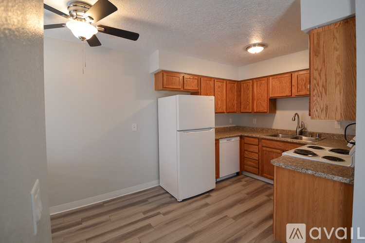 A kitchen with wooden cabinets and a white refrigerator.