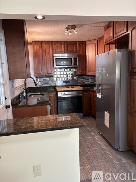 A kitchen with a refrigerator, oven, and microwave.