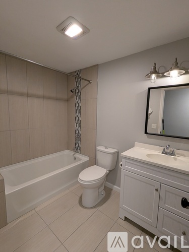 A bathroom with a white tub, toilet, and sink.