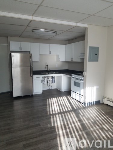 A kitchen with a refrigerator, sink, and stove.