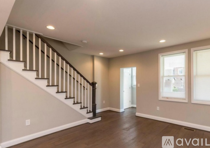 A spacious room with a staircase and a window.
