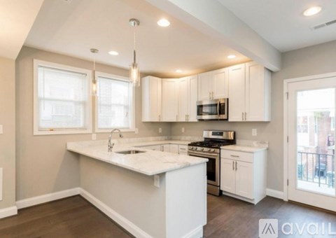 A kitchen with white cabinets and a large island.