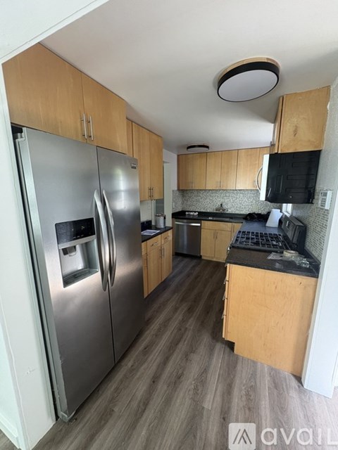 A kitchen with a refrigerator, microwave, and oven.
