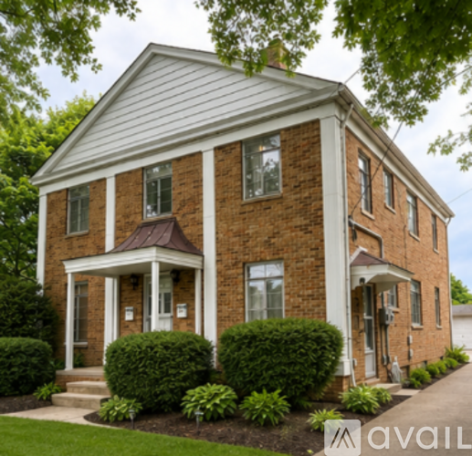 A brick house with a porch and a white trim.