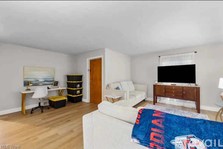 A bedroom with a bed, a couch, a desk, and a television.