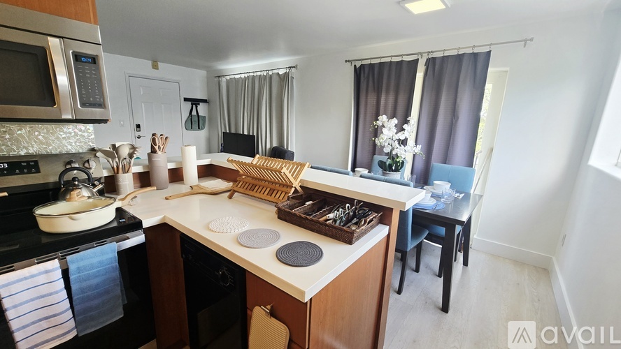 A kitchen with a stove, microwave, and dining table.