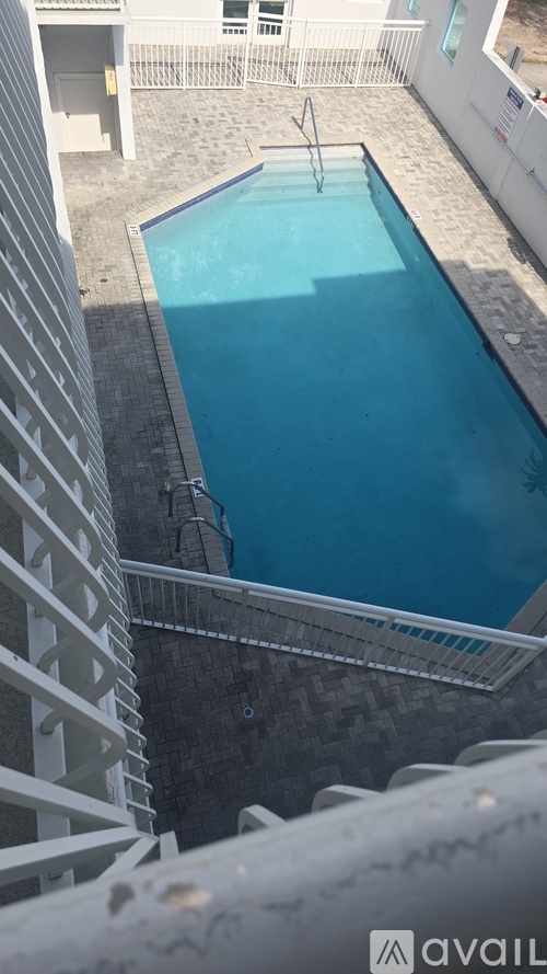 A small pool in a courtyard surrounded by white buildings.