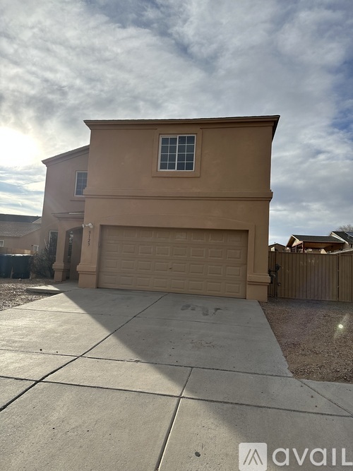 A beige house with a garage door and a window.