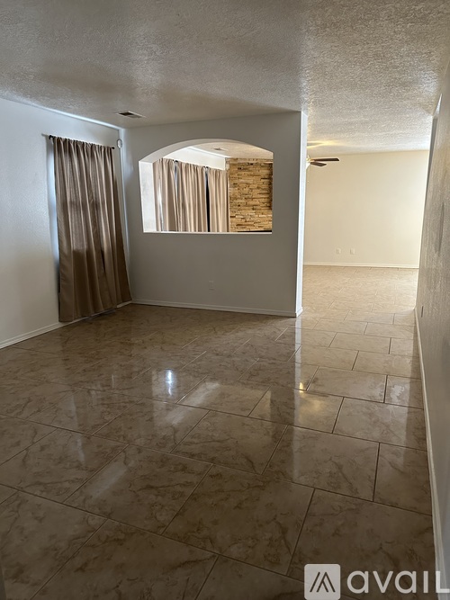 A room with a tiled floor and a window with curtains.